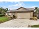 Tan house with a brown roof and a two-car garage at 2700 Dorado Ct, Apopka, FL 32703