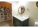 Bathroom with single vanity, round mirror, and photo wall at 3202 Alling, Deltona, FL 32725