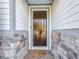 Inviting front entry with dark brown door, stone accents, and a welcoming mat at 3465 Middlebrook Pl, Harmony, FL 34773