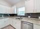 Kitchen features white cabinets, granite counters, and stainless steel dishwasher at 3465 Middlebrook Pl, Harmony, FL 34773