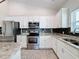 Modern kitchen featuring white cabinets, granite counters, and stainless steel appliances at 3465 Middlebrook Pl, Harmony, FL 34773