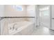 Relaxing bathroom featuring a soaking tub, tile flooring, and updated fixtures at 3975 Great Smokey Way, Apopka, FL 32712