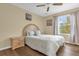 Bright bedroom with wood floors, queen bed, and large window at 4765 Ormond Beach Way, Kissimmee, FL 34746