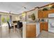 Kitchen with light wood cabinets, white appliances, and a breakfast bar at 4765 Ormond Beach Way, Kissimmee, FL 34746