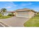 House exterior featuring a large garage and brick paver driveway at 490 Sweetwater Way, Haines City, FL 33844