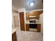 Kitchen with wood cabinets, stove, and adjacent laundry area at 5022 Log Wagon Rd, Ocoee, FL 34761