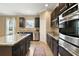 Modern kitchen with dark cabinetry, granite counters, and stainless steel appliances at 745 Andrew St, Eustis, FL 32726