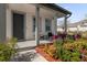 Covered front porch with seating and colorful landscaping at 9118 Waverly Walk Dr, Orlando, FL 32817