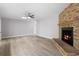 Living room with brick fireplace, ceiling fan, and light wood flooring at 10140 Bridlewood Ave, Orlando, FL 32825