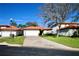 House exterior showcasing a two car garage and well maintained lawn at 142 Sandy Point Way, Clermont, FL 34714