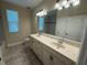 Double vanity bathroom with a large mirror and neutral tones at 15306 Southern Martin St, Winter Garden, FL 34787