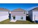 A view of the home's back and a small patio at 1534 Marksman Rd, Eagle Lake, FL 33839