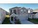 Two-story house with gray siding, a gray garage door, and landscaping at 1534 Marksman Rd, Eagle Lake, FL 33839