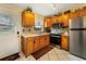 Galley kitchen featuring wooden cabinets, granite counters, tile backsplash and stainless steel appliances at 160 Clay Cut Cir, Haines City, FL 33844