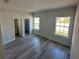 Bright bedroom with wood-look floors, two windows, and a closet at 1617 Cumin Dr, Kissimmee, FL 34759