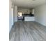 Open concept living area with wood-look floors and an adjacent kitchen at 1617 Cumin Dr, Kissimmee, FL 34759