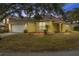 House exterior at dusk, yellow siding, attached garage, and well-manicured lawn at 1685 Waterview Loop, Haines City, FL 33844