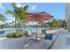 Seating area near the pool with table and chairs under umbrella at 1694 Three Bars Rd, Kissimmee, FL 34744