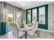 Bright dining room with white table and chairs, teal accent wall, and view to backyard at 1741 Three Bars Rd, Kissimmee, FL 34744