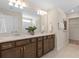 Double vanity bathroom with modern brown cabinets and a large mirror at 2436 Belle Haven Way, Davenport, FL 33896