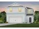 Two-story house with light blue and white siding, white garage door, and landscaping at 2436 Belle Haven Way, Davenport, FL 33896