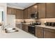 Kitchen features dark brown cabinets, stainless steel appliances and double sink at 2436 Belle Haven Way, Davenport, FL 33896