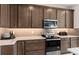 Kitchen with dark brown cabinets, stainless steel appliances, and quartz countertops at 2436 Belle Haven Way, Davenport, FL 33896