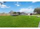 Gray house with a fenced yard, palm trees, and a large green lawn at 3662 Mohawk Dr, Mount Dora, FL 32757