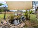 Serene backyard pond with shade sail, landscaping, and wooden bench at 3662 Mohawk Dr, Mount Dora, FL 32757