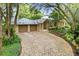 Brick driveway leading to a two-car garage with lush landscaping at 451 Northwind Rd, Maitland, FL 32751