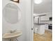 Small bathroom with pedestal sink and round mirror at 466 W Par St # 466, Orlando, FL 32804