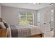 Bedroom with wood flooring and large window offering a nature view at 466 W Par St # 466, Orlando, FL 32804