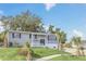 Gray house with white garage door, landscaping, and palm trees at 4862 Indialantic Dr, Orlando, FL 32808