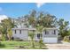 Gray house with white garage door, landscaping, and palm trees at 4862 Indialantic Dr, Orlando, FL 32808