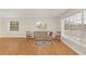 Bright living room with hardwood floors, large windows, and vintage furniture at 4862 Indialantic Dr, Orlando, FL 32808