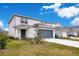 Two-story house with grey garage door and landscaped yard at 5302 Royal Point Ave, Kissimmee, FL 34746