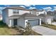 Two-story house with gray garage door and light beige siding at 5302 Royal Point Ave, Kissimmee, FL 34746