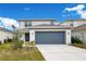 Two-story house with gray siding, two-car garage, and landscaping at 5302 Royal Point Ave, Kissimmee, FL 34746