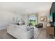 Living area with white sofas, a green chair, and sliding doors at 5513 Hanover Square Dr, St Cloud, FL 34771