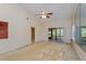 Spacious living room featuring a ceiling fan, neutral carpet, and sliding glass doors to the screened porch at 596 Albany Pl, Longwood, FL 32779