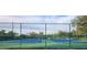 Well-maintained tennis courts enclosed by a green fence, under a sunny sky with scattered clouds at 596 Albany Pl, Longwood, FL 32779