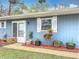 Side entrance with red mulch, potted plants and walkway at 608 Powers Ave, Port Orange, FL 32127