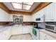 Galley kitchen with white cabinets, wood details, and modern appliances at 628 Twin Oaks Cir, Daytona Beach, FL 32117