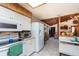 White kitchen with wood accents, featuring a stove, microwave, and refrigerator at 628 Twin Oaks Cir, Daytona Beach, FL 32117