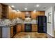 Modern kitchen with wood cabinets, stone backsplash, and concrete floors at 717 Glasgow Ct, Winter Springs, FL 32708