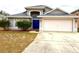 Two-story house with gray siding, attached garage, and blue front door at 800 Woodlark Dr, Davenport, FL 33897