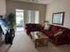 Living room with burgundy sofas and access to patio at 800 Woodlark Dr, Davenport, FL 33897