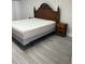 King-size bed, wooden headboard, and gray wood-look floors at 8421 S Orange Blossom Trl # 321, Orlando, FL 32809
