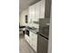 Small kitchenette with white cabinets, granite countertops, and stainless steel appliances at 8421 S Orange Blossom Trl # 321, Orlando, FL 32809