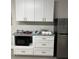 Small kitchen with microwave, cabinets, and granite countertops at 8421 S Orange Blossom Trl # 321, Orlando, FL 32809